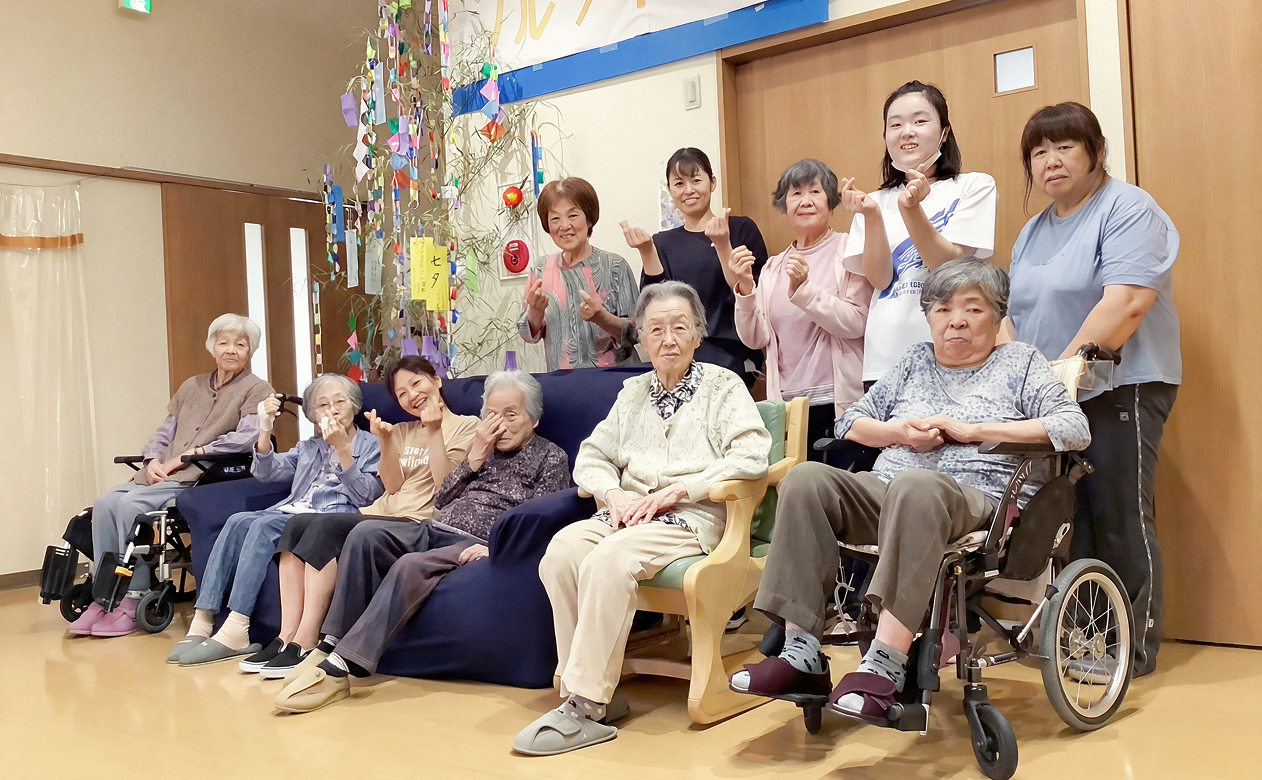 複数人の高齢者と介護士が座っている