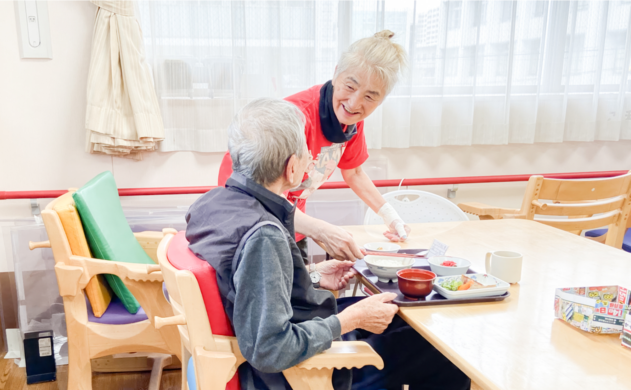 高齢な男女が笑顔で談笑している