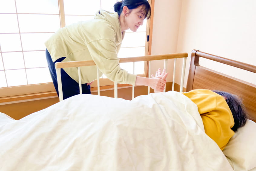 女性理学療法士が高齢者と会話している