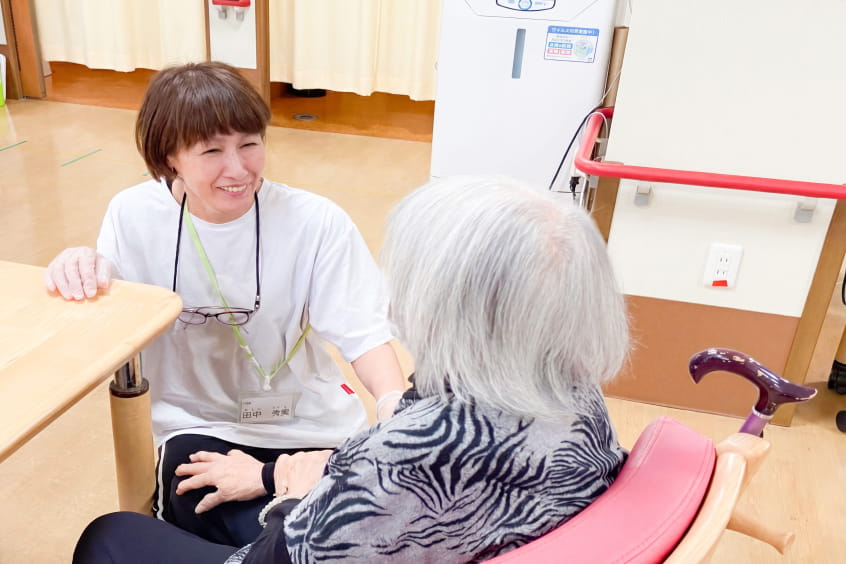 介護士と高齢女性が会話する様子