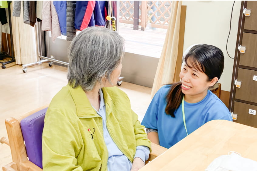 介護士と話す高齢女性