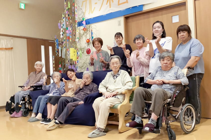複数人の高齢者と介護士が座っている