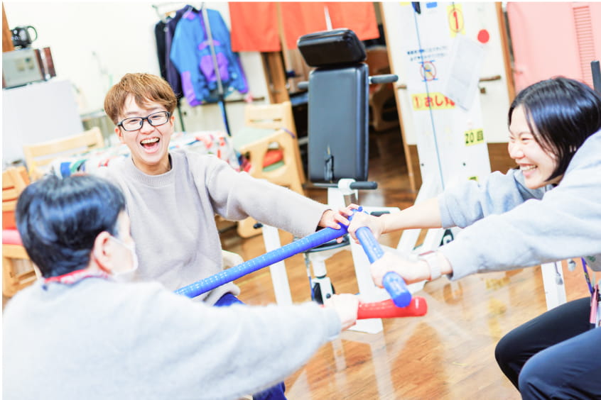 3人の人物がカラフルな棒を使い運動する様子