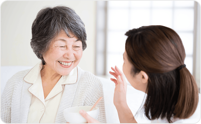 介護を受ける高齢女性と介助する女性
